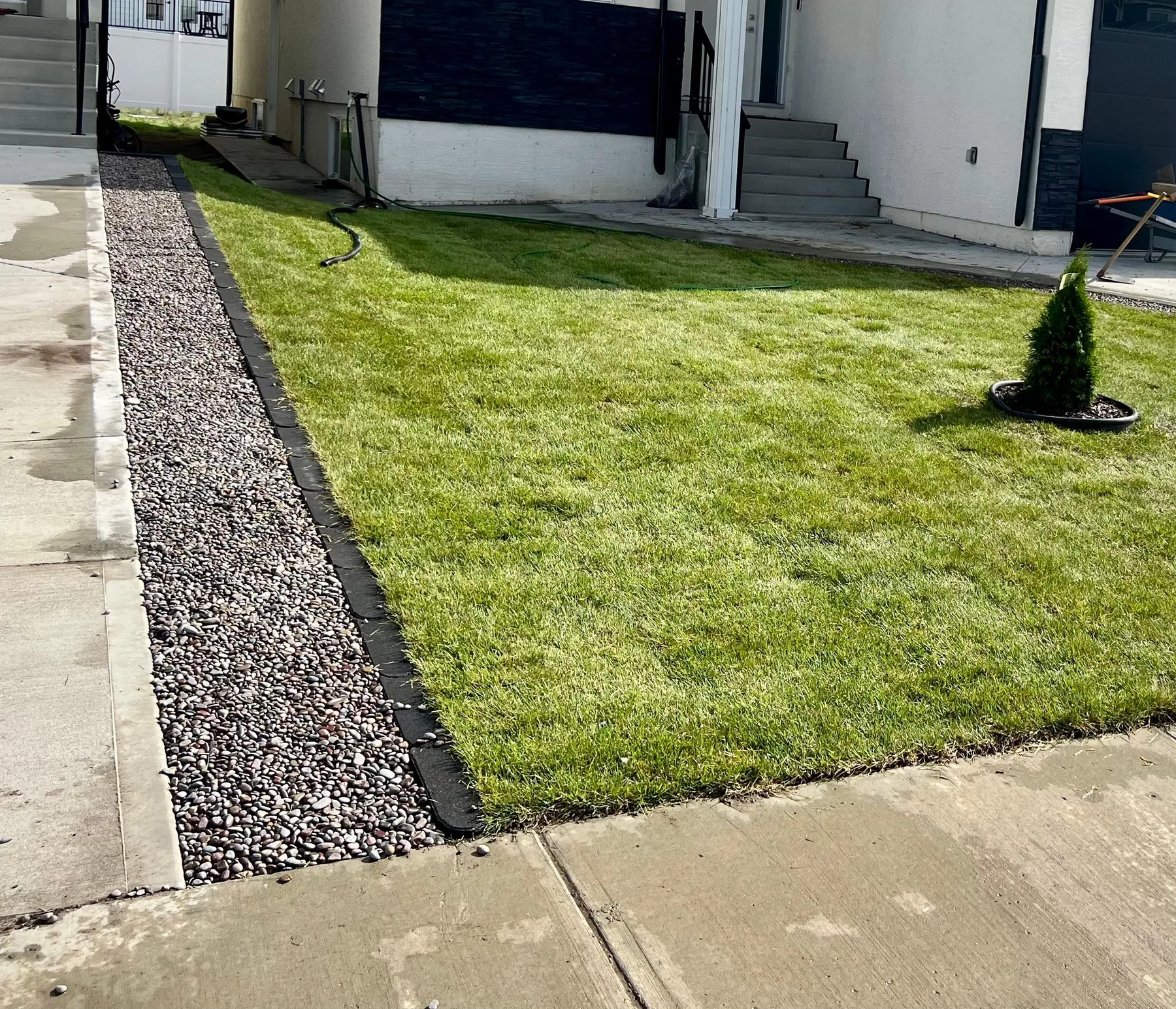 Finished lawn with curved rock bed edging